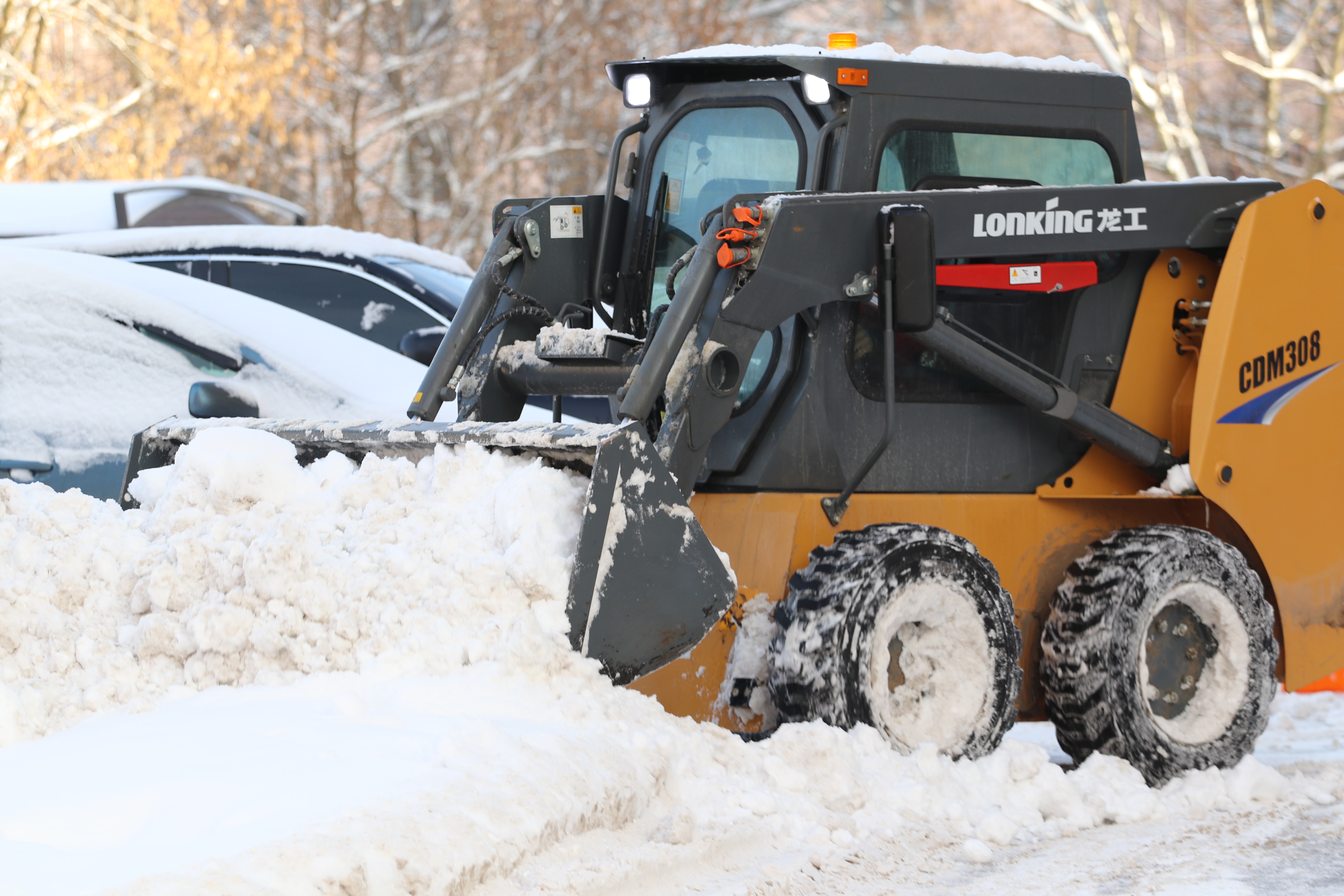 A tractor removing snow from a parking lot
